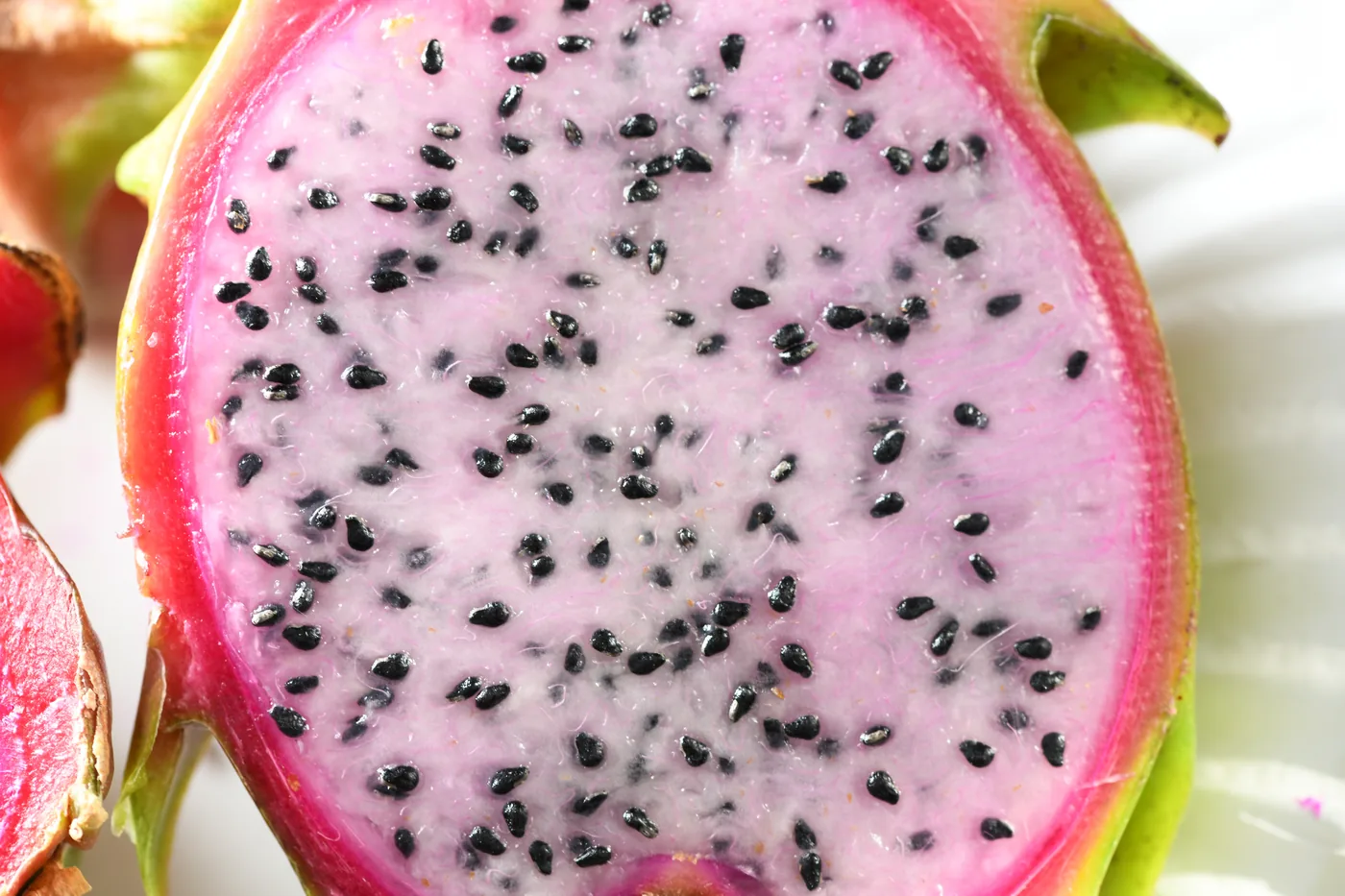A close view of dragon fruit pulp covered in small black seeds
