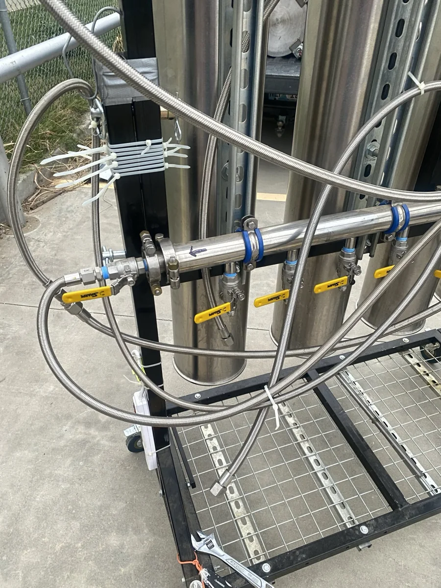 A stainless steel extraction rack with braided hoses and fittings